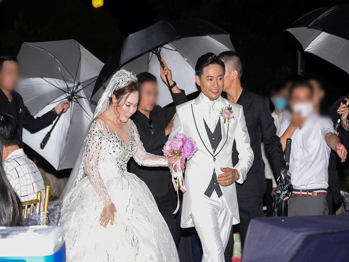 Diễn viên Quý Bình - doanh nhân Ngọc Tiền cũng dùng ô che chắn hình ảnh trong đám cưới. Ảnh: Dân Việt.
