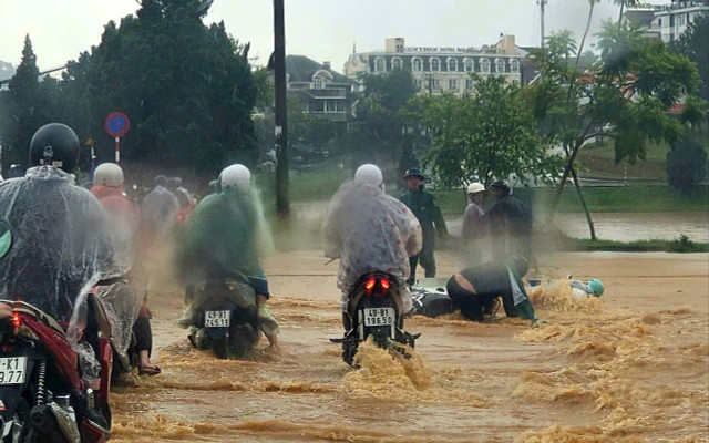 Dòng nước chảy mạnh từ dốc cao gây nguy hiểm cho phương tiện qua lại, nhiều người bị trượt ngã. Ảnh: NDCC 16-6-1.jpg