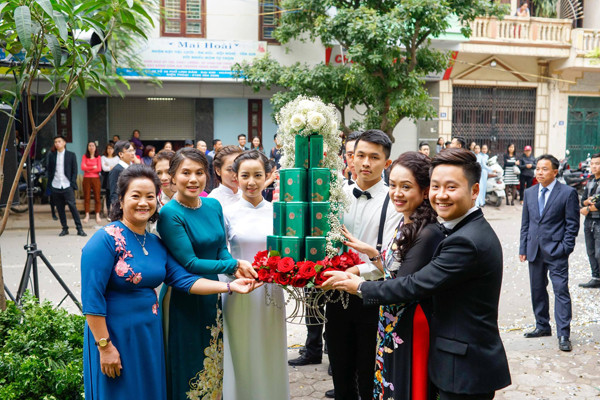 Nhà chồng của Mai Ngọc xuất hiện lúc 13 giờ chiều. Tất cả các thành viên của gia đình đều ăn mặc rất sang trọng, tươi vui và cùng chung niềm vui với cặp trai tài gái sắc.