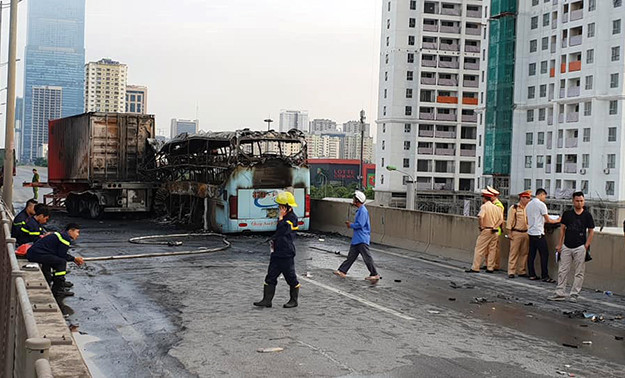 Phần đuôi bên phải bánh rơmoóc xe biển 34B-019.06 bị nổ lốp và cháy rụi. Ngoài ra, một xe máy ở cạnh ô tô khách cũng trong tình trạng cháy rụi.