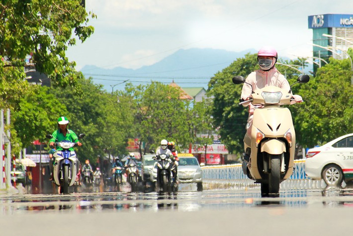 Nhiệt độ cao mang đến cảm giác mặt đường bị ướt, hình ảnh các phương tiện đi trên đường bị làm mờ, biến dạng. Ảnh: NGUYỄN DO