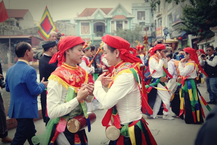 Điệu múa "Con đĩ đánh bồng" được thực hiện bởi 5 cặp đôi trai giả gái làng Triều khúc. Các thanh niên làng ngoài việc tô son thoa phấn, họ còn chít khăn, mặc áo mớ ba mớ bảy, nhưng phải đưa mắt lúng liếng, nhảy múa, lắc lư uyển chuyển, nhịp nhàng để bà con tán thưởng.