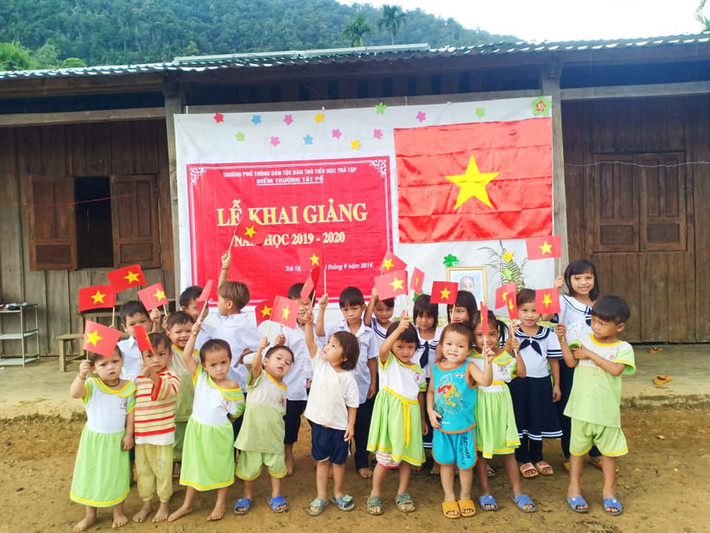 Các em cùng giơ lá cờ tổ quốc chụp hình chào mừng khai giảng.