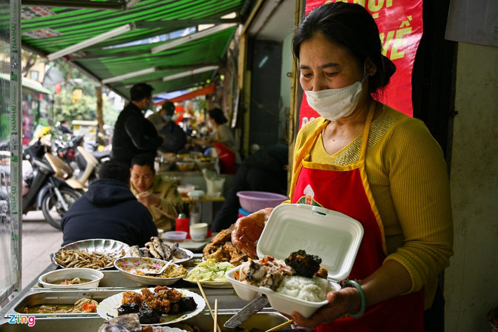 Hai cửa hàng cơm bình dân tại phố Phan Huy Chú, phường Phan Chu Trinh có hoàn cảnh trái ngược, quán bên cạnh có khách ăn tại chỗ, trong khi đó quán của bà Nga chủ yếu bán mang về. Mặc dù bàn ghế vẫn được dọn ra, bà cho biết chẳng có mấy khách, đa số là người quen từ trước đặt mang về.