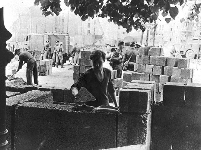 Ngày 13/8/1961, bức tường Berlin bắt đầu được dựng lên. Ảnh: Một công nhân Đông Đức đặt những khối gạch đầu tiên của Bức tường Berlin.