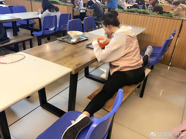 Và đây mới là hình ảnh thật trong giờ ăn trưa của cô sinh viên trẻ: Vừa ăn vừa xoạc chân.