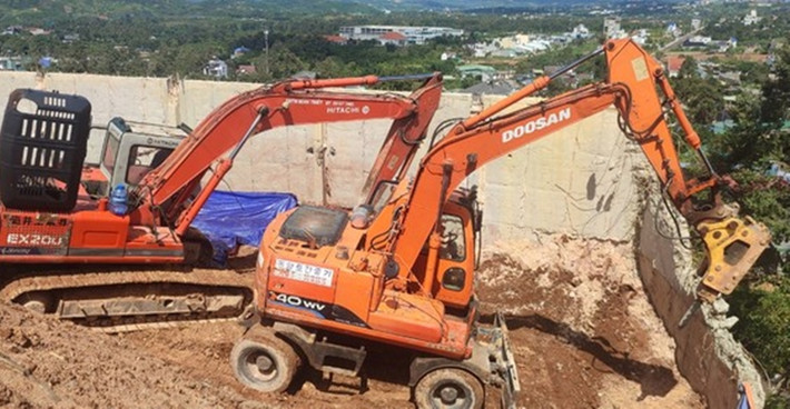 Ngay trong ngày nhận quyết định xử phạt, chủ đầu tư đã huy động 3 máy múc và nhiều công nhân tiến hành tháo dỡ bờ ta luy không phép. (Ảnh: Tiền Phong).