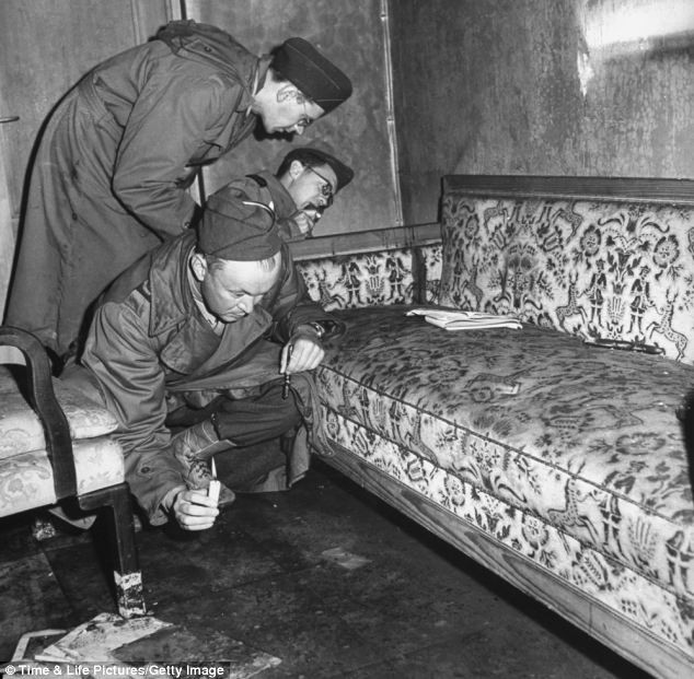 Phóng viên chiến trường kiểm tra ghế sofa dính máu. Họ cho rằng đây có thể là máu của Hitler bắn ra sau khi trùm phát xít tự sát.