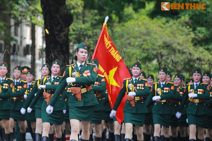 Các nữ sỹ quan thông tin với khuôn mặt tươi rói, rạng rỡ bên lá cờ in đậm dòng chữ "Quyết thắng".
