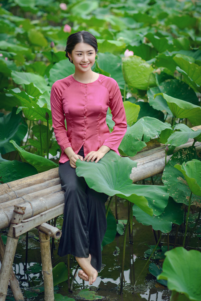 Khác với nhiều thiếu nữ, Ngọc Linh không diện yếm đào "hờ hững" mà lại chọn áo bà ba, hóa thân thành cô thôn nữ, tạo dáng bên sen.