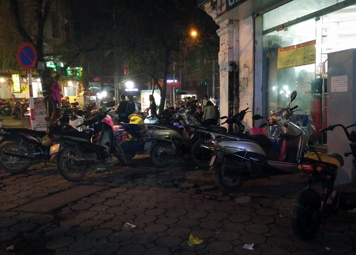 Tại nút giao thông đường Trần Bình - Mỹ Đình (phường Mỹ Đình 2, quận Nam Từ Liêm, Hà Nội), vào buổi tối, nhiều quán ăn vỉa hè ngang nhiên lấn chiếm hết phần đường dành cho người đi bộ, xe cộ xếp lộn xộn.