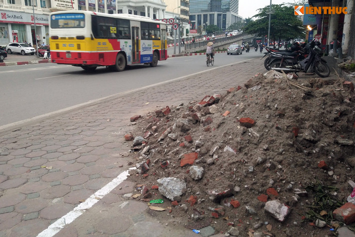 Trên đường Láng Hạ, một đống vật liệu xây dựng rất to đổ ngay trên vỉa hè lấn chiếm hết diện tích phần đường dành cho người đi bộ.