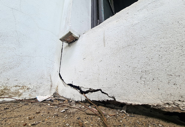 Các vết rạn nứt lớn còn xuất hiện ở nhiều vị trí tường sát nền móng nhà.