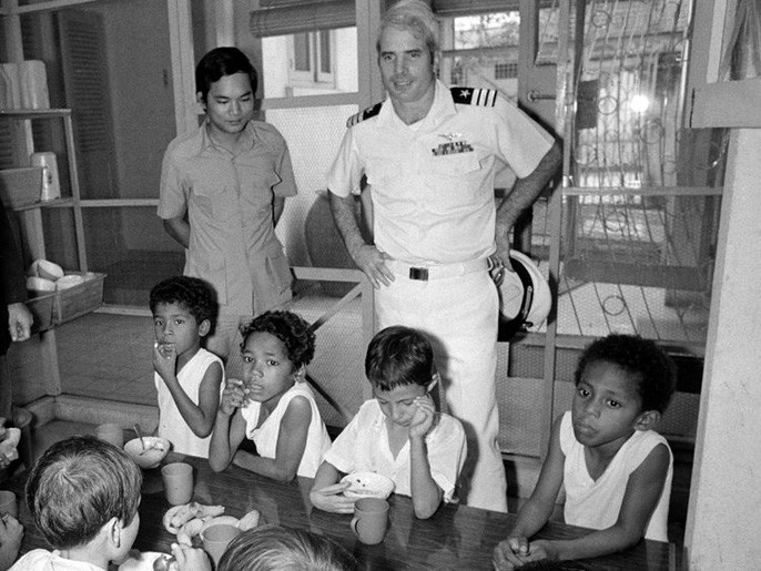 Sau khi được trả tự do, ông McCain tiếp tục phục vụ cho Hải quân Mỹ với vai trò liên lạc viên và nhiều lần quay lại Việt Nam để cải thiện quan hệ Việt Nam - Mỹ. Ảnh chụp ông McCain viếng thăm một trại mồ côi tại Sài Gòn ngày 30/10/1974. Ảnh: AP.