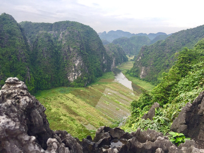 Điểm đặc biệt nhất ở Hang Múa - Ninh Bình có lẽ là núi non trùng điệp bao quanh, giữa ngọn núi xanh mướt ấy là cánh đồng lúa, dòng sông uốn lượn. Đôi khi bạn sẽ thấy cảnh thuyền rẽ sóng trên sông.