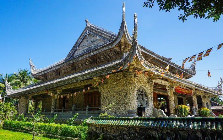 Từng khối san hô bao được mang về phân loại, kỳ công đẽo gọt và mài nhẵn. Sau đó được ốp trang trí mái, lam, đầu rường, mặt tiền theo hình chữ vạn hoặc hình kỷ hà, ngọn sóng. Nội thất bên trong sử dụng muôn vạn mảnh gáo dừa lắp ghép ốp tường tạo hình thay gỗ với các sắc màu nâu, đen, trắng xen lẫn hài hòa.