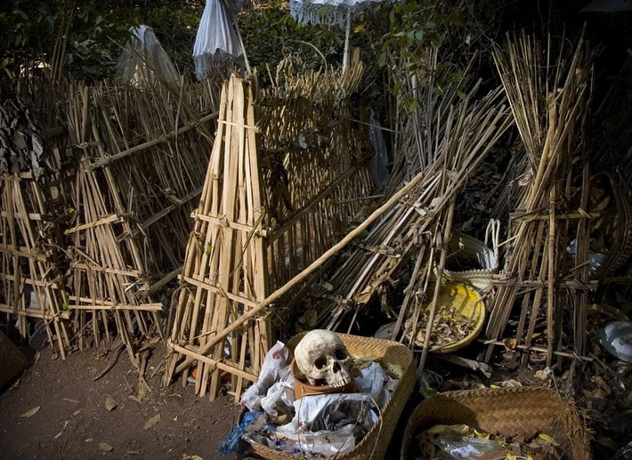 Tục phơi thây người chết trong lồng tre trên đảo Bali (Trunyan Cemetery): Trunyan, ngôi làng miền núi trên bờ đông hồ Batur là nơi duy nhất ở Bali vẫn giữ nghi lễ cổ đại này. Khi một người trong làng qua đời, cơ thể không được chôn cất hoặc hỏa tang mà đặt trong một lồng tre để tự phân hủy. Cho đến khi tất cả xác thịt tan rã, người ta lấy hộp sọ ra khỏi phần còn lại của bộ xương và đặt lên bàn thờ bằng đá bên dưới một cây thiêng liêng. Ảnh: Dewi Putra.
