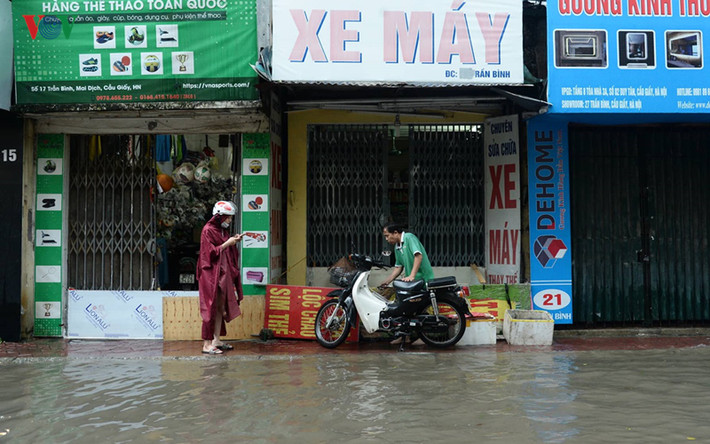 Cuộc sống của nhiều hộ dân tại đoạn phố Trần Bình đã bị ảnh hưởng, nhiều cửa hàng phải đóng cửa và tìm cách che chắn không cho nước ngập tràn vào nhà.