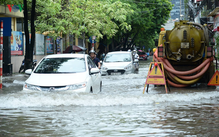 Do ảnh hưởng của cơn bão số 3 - Wipha, ô tô biến thành "xe lội nước" vì đường ngập sâu sau một ngày mưa kéo dài.
