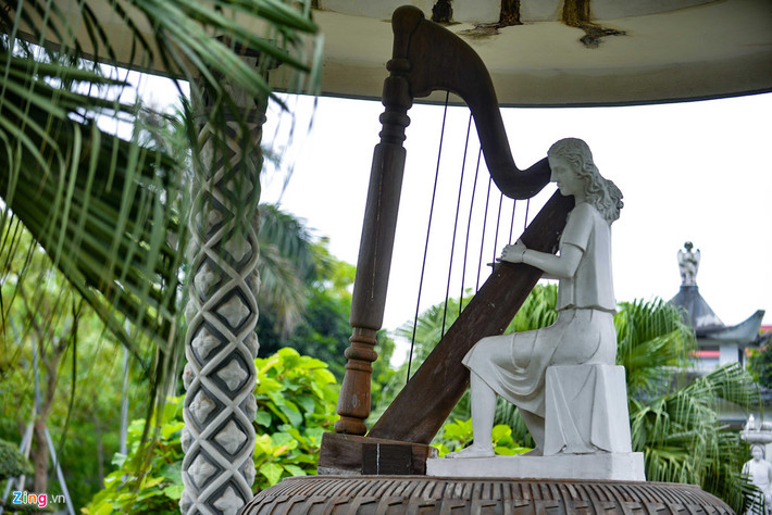 Cách đó không xa là tượng một cô gái đang gảy đàn harp, ngồi trên bệ tròn hình trống đồng.