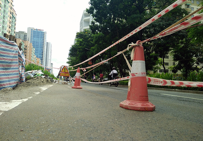 Các biển báo "Xí nghiệp thoát nước số 2" và dây công trình được kéo xung quanh khu vực bị sạt lở cảnh báo người đi đường biết.