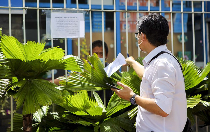 Nhân viên cửa hàng nhận đơn qua hàng rào, vì cửa hàng không tiếp nhận khách trực tiếp.