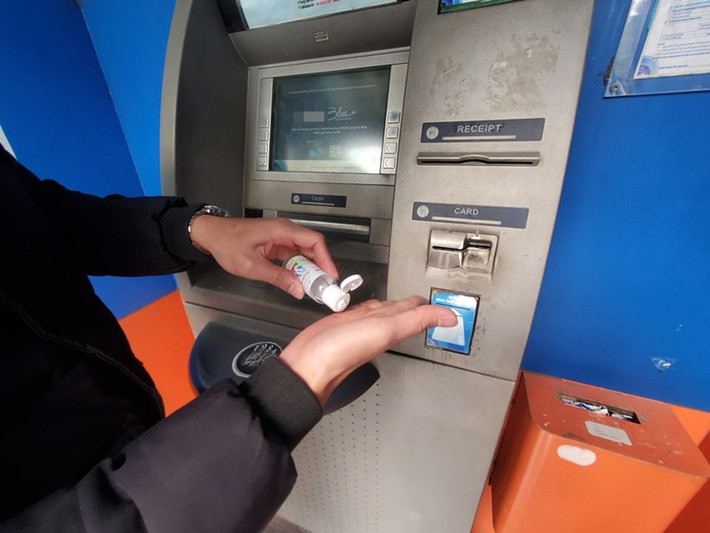 Một khách hàng đã phải lấy nước rửa tay diệt khuẩn mang sẵn trong người ra để sử dụng, sau khi rút tiền tại cây ATM đen xì.