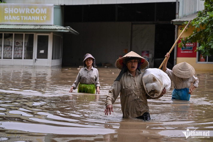 Nữ công nhân làm việc tại một nhà xưởng cạnh đoạn ngập cho biết, mấy hôm nay phải vận chuyển đồ trong kho ra bên ngoài. Đây là đoạn ngập sâu nhất, phía trong nước dâng đến bụng.
