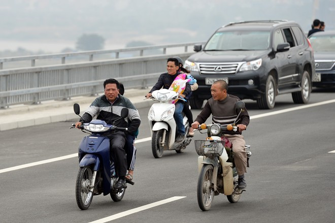 Nhiều người không đội mũ bảo hiểm, phóng lòng vòng quanh cầu ngắm cảnh.