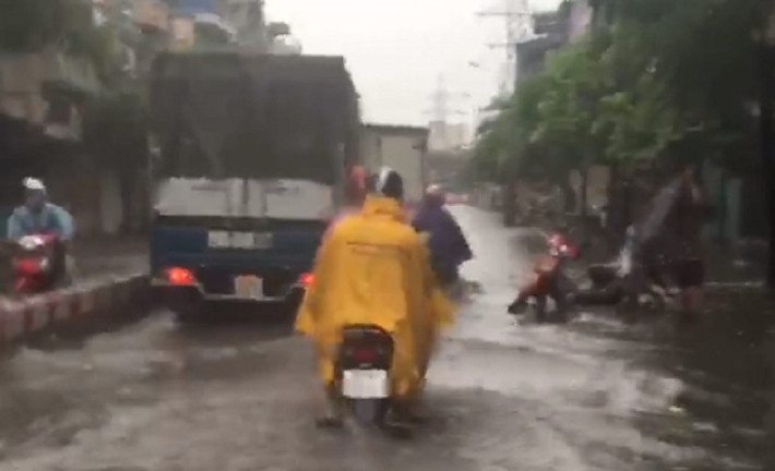 Các phương tiện tham gia lưu thông trên đường Minh Khai phải đi rất chậm vì nước ngập sâu.
