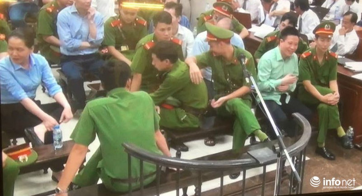 Tại lần xét xử này Hà Văn Thắm, Phạm Công Danh, Nguyễn Minh Thu không được đưa về khu vực tố tụng vào giờ nghỉ giải lao giữa phiên xử. Mặc dù, trước tội danh chồng chất và có thể đối mặt với mức án cao nhất nhưng chiều 29/8, khi ở lại phòng xét xử Hà Văn Thắm (bên phải) lại tỏ ra khá thoải mái khi nói chuyện với các cảnh sát. Ảnh: Infonet.