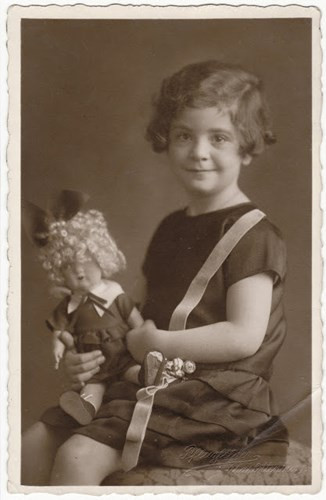 Marion Bassfrend chụp ảnh cùng búp bê ở Anh vào năm 1938. Bố mẹ của em đã bị Đức Quốc xã giết hại vào tháng 11/1941 tại Kaunas.