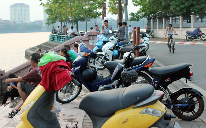 Xe đạp, xe máy của những người đến tắm xếp dài trên bờ hồ mà không có ai trông coi.