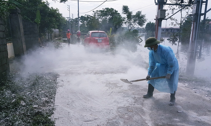 Hơn chục tấn vôi bột được chính quyền xã mua, rải khắp các đường trong xã để khử trùng dịch bệnh.