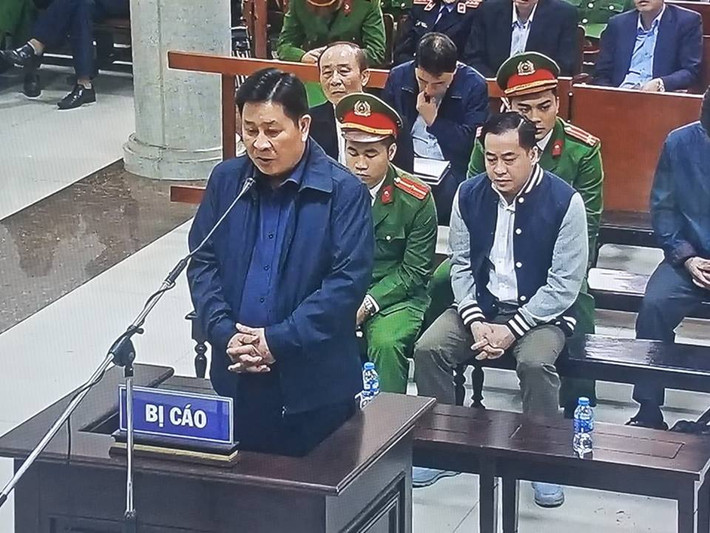 Bị cáo Bùi Văn Thành đứng lên trả lời căn cước. (Ảnh chụp qua màn hình).