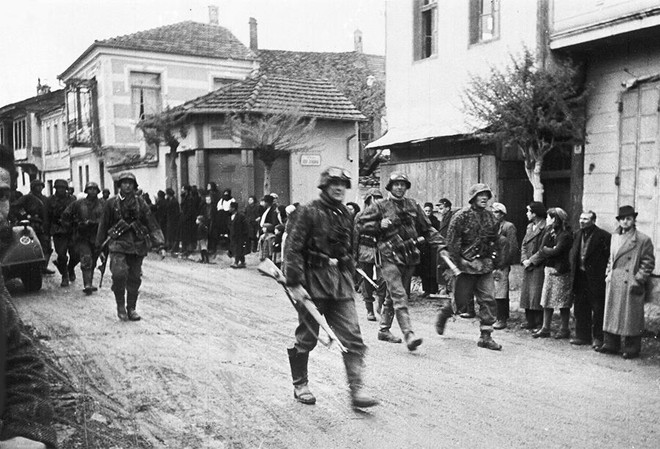 Một nhóm binh sĩ Đức đi qua ngôi làng ở Hy Lạp tháng 5/1941, trong giai đoạn Đức Quốc xã tấn công Hy Lạp.