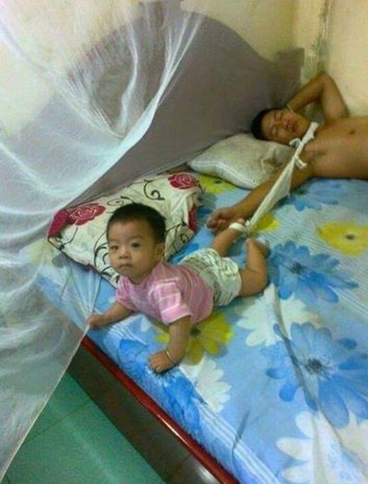 Luôn giữ vững trọng trách quan trọng, ngay cả lúc ngủ ông bố này cũng phải nhớ nhiệm vụ trông con. Hai mảnh khăn 1 đầu buộc cổ chân con, đầu còn lại buộc vào cổ bố, quá choáng với cách chăm con cực kỳ bá đạo của ông bố này.