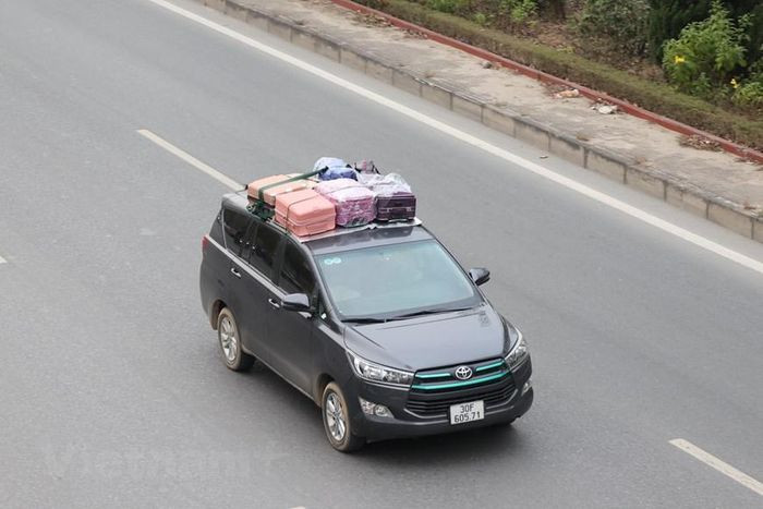 Một số người dân với lượng hành lý 'quá khổ' đã phải chia nhỏ để buộc cố định trên nóc xe ôtô. (Ảnh: Minh Sơn/Vietnam+)