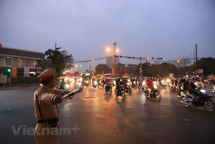 Lực lượng chức năng túc trực tại các nút giao để điều tiết, hướng dẫn các phương tiện di chuyển theo đúng làn đường. (Ảnh: Hoài Nam/Vietnam+)
