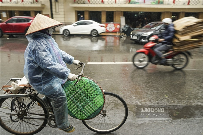 Dưới cái lạnh như cắt da thịt ở Hà Nội, nhiều người lao động nghèo vẫn lặng lẽ mưu sinh. (Ảnh: Lao Động).