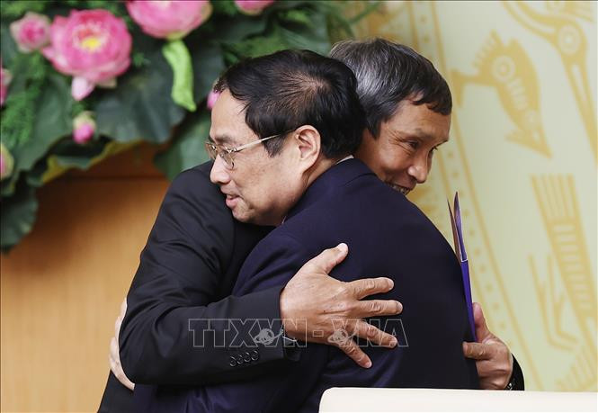 Thủ tướng Phạm Minh Chính chúc mừng Huấn luyện viên Mai Đức Chung. (Ảnh: TTXVN).