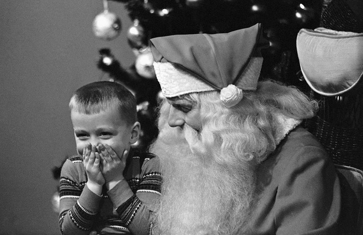 Ngày 16/12/1960, cậu bé Eddie Waymel (4 tuổi) đã có cơ hội gặp ông già Noel tại một cửa hàng bách hóa ở Chicago. Sau khi kể cho ông nghe về món quà mơ ước của mình, cậu bé che miệng cười khúc khích vì xấu hổ. Có vẻ như bộ râu đặc biệt của ông già Noel đã khiến Eddie hào hứng hơn rất nhiều. Ảnh: Bettmann.