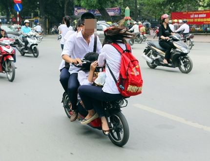 Học sinh kẹp 3-4 người, ngồi đủ các dáng kỳ quái trên xe đạp điện, tạo nên một hình ảnh "sởn da gà" trên đường phố.