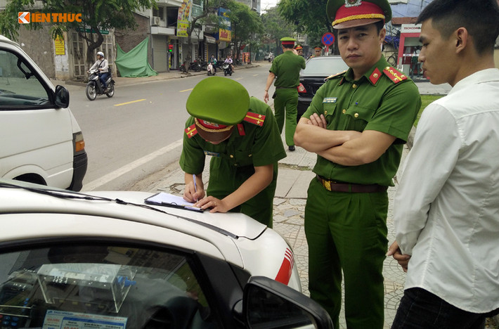 Lực lượng chức năng kiên quyết xử lý chiếc xe taxi vi phạm. Ảnh chụp trên đường Thụy Khuê.