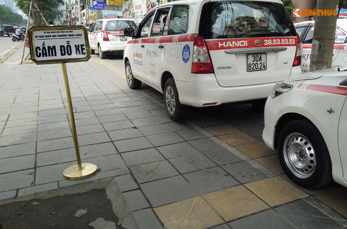 Trên một đoạn đường Láng Hạ (Hà Nội), xe taxi ngang nhiên dừng đỗ trên vỉa hè, thậm chí là đỗ thành hàng ngay trước cổng một số cơ quan, doanh nghiệp cho dù có biển thông báo cấm đỗ.