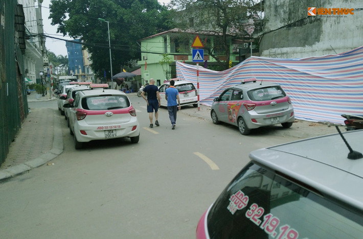 Tương tự, trên một con ngõ ở đường Thụy Khuê, nhiều xe taxi đỗ tràn lan xuống lòng đường, lấn chiếm cả vỉa hè khiến người đi bộ phải di chuyển xuống lòng đường.