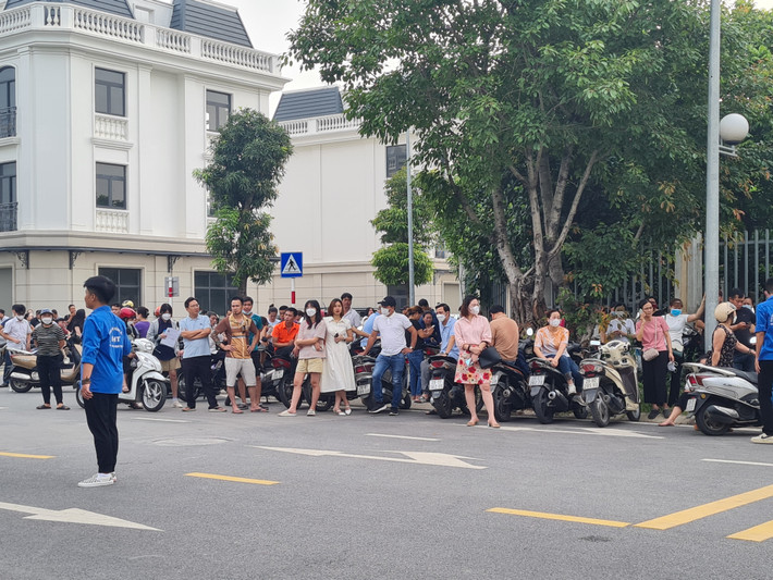 Các phụ huynh đứng chờ con ngoài cổng trường.