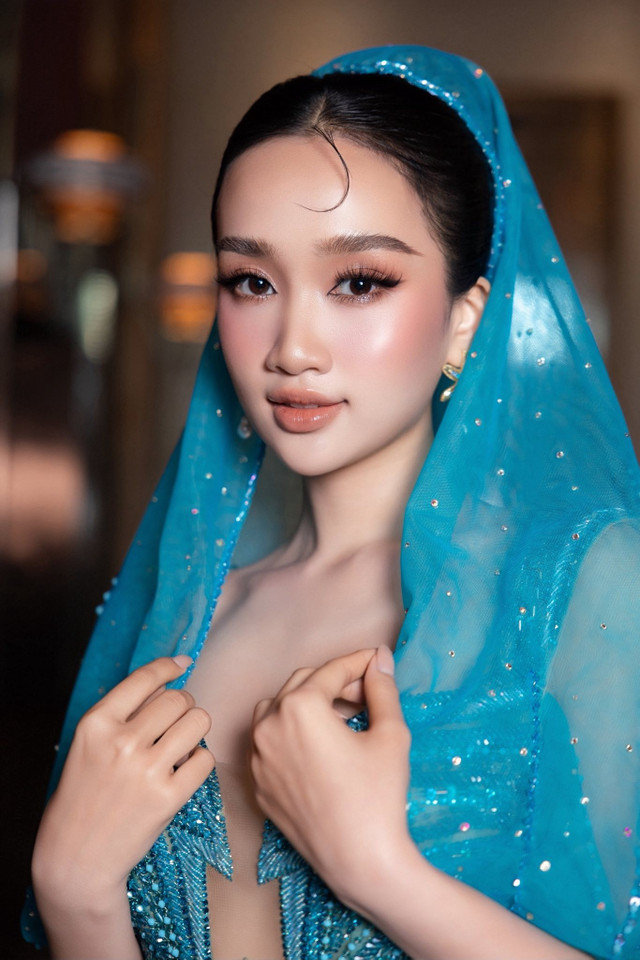 Chiếc khăn voan đính đá khoác hờ trên vai tạo nét mềm mại, như làn sóng xanh ôm lấy người đẹp. Sự trẻ trung, tươi mát nhưng đầy khí chất giúp cô nổi bật và tạo động lực cho các thí sinh. hhsv-1.jpg