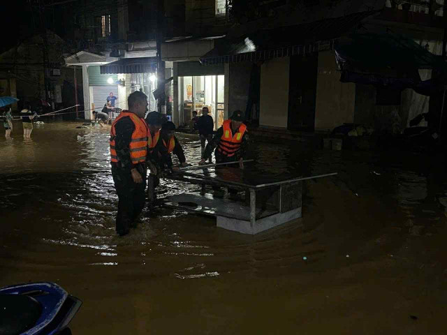 Lực lượng chức năng hỗ trợ người dân tại phường Yên Bái vận chuyển đồ đạc đến vị trí an toàn. Ảnh: Đức Mậu ngap-2.jpg