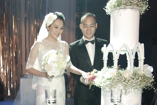 Cô dâu chú rể hạnh phúc làm nghi lễ cắt bánh cưới
